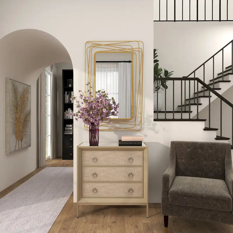 Commode 3 tiroirs en bois beige, avec finition capitonnée, plateau miroir et poignées anneaux.